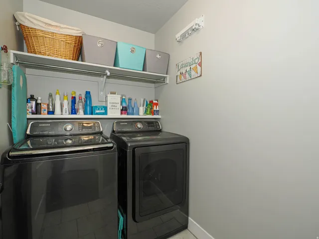 Dedicated laundry area with upper shelving for storage