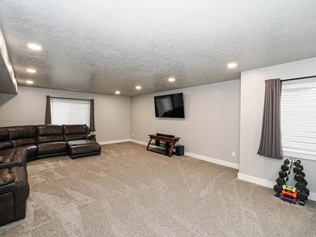 Spacious room with light gray walls, textured ceiling, and recessed lighting