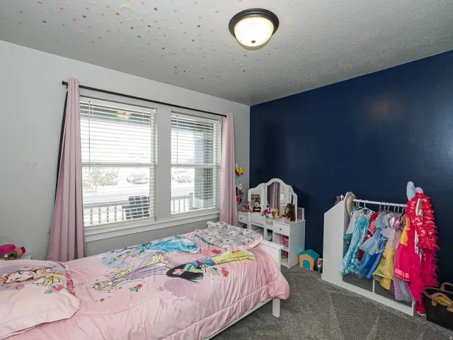 Interior room featuring textured ceiling, flush-mount lighting, and two windows with blinds