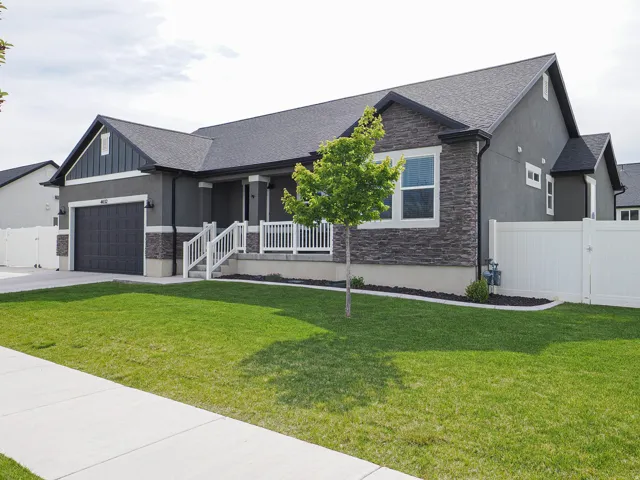 Contemporary exterior featuring dark gray stucco and stacked stone accents