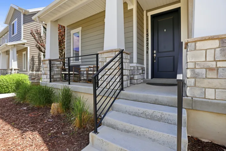 Entry features a darling porch and dark colored door.