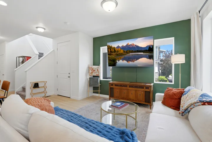 Open concept living space featuring a distinct accent wall, recessed ceiling lighting, and light wood-finish flooring