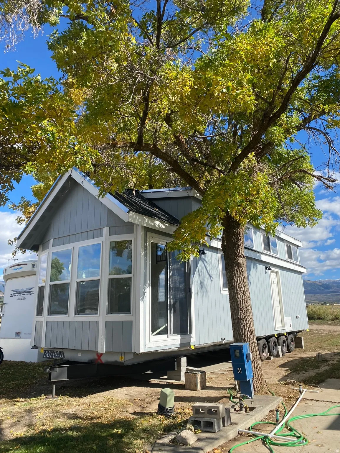 Light blue siding exterior with white trim and a black shingled roof