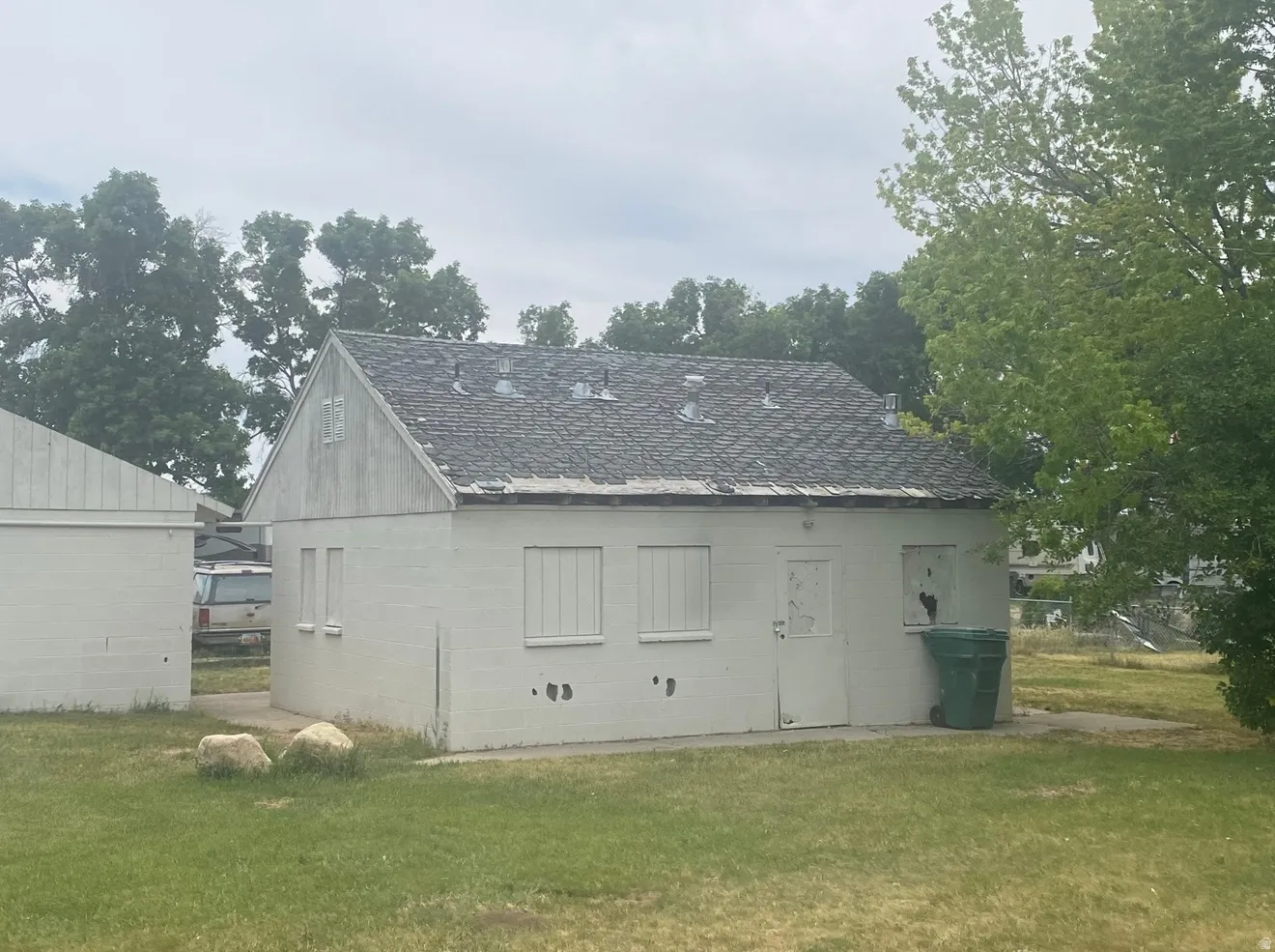 White-painted exterior structure with a gabled roof and gray shingles