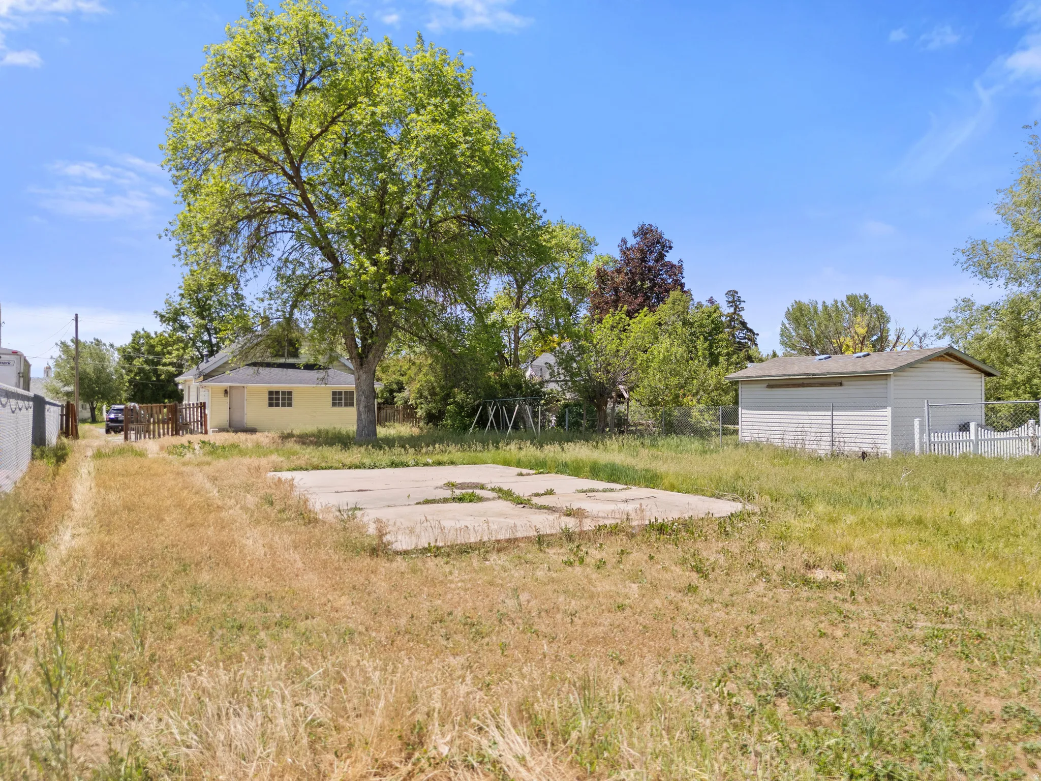 Expansive yard featuring a large concrete pad for another outbuilding our your fire pit and cookouts!