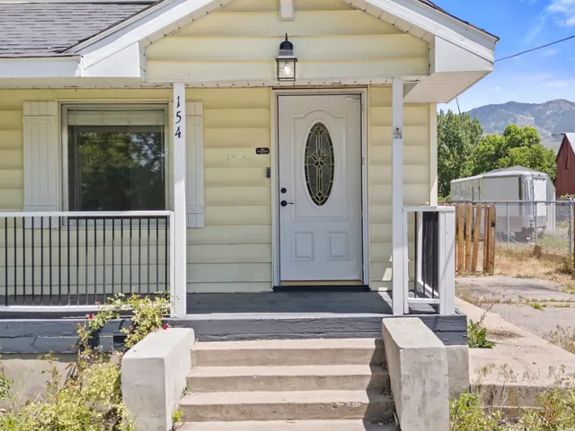Front entry featuring a white oval-lite door with decorative glass, covered porch, and concrete steps