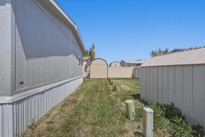 Rear exterior with tan vertical siding and white foundation skirting