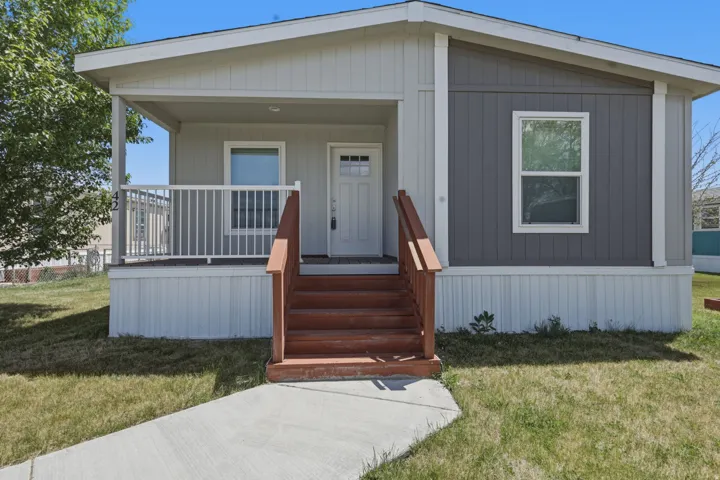 Contemporary single-story residence with a covered front porch featuring white railing