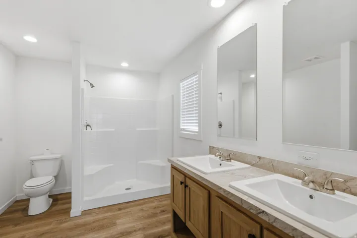 Bathroom featuring a dual vanity with rectangular sinks and a stone-finish countertop