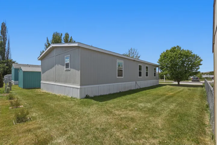 Spacious exterior featuring light gray horizontal siding and white trim