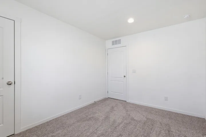 Room featuring neutral wall finishes and grey textured carpeting