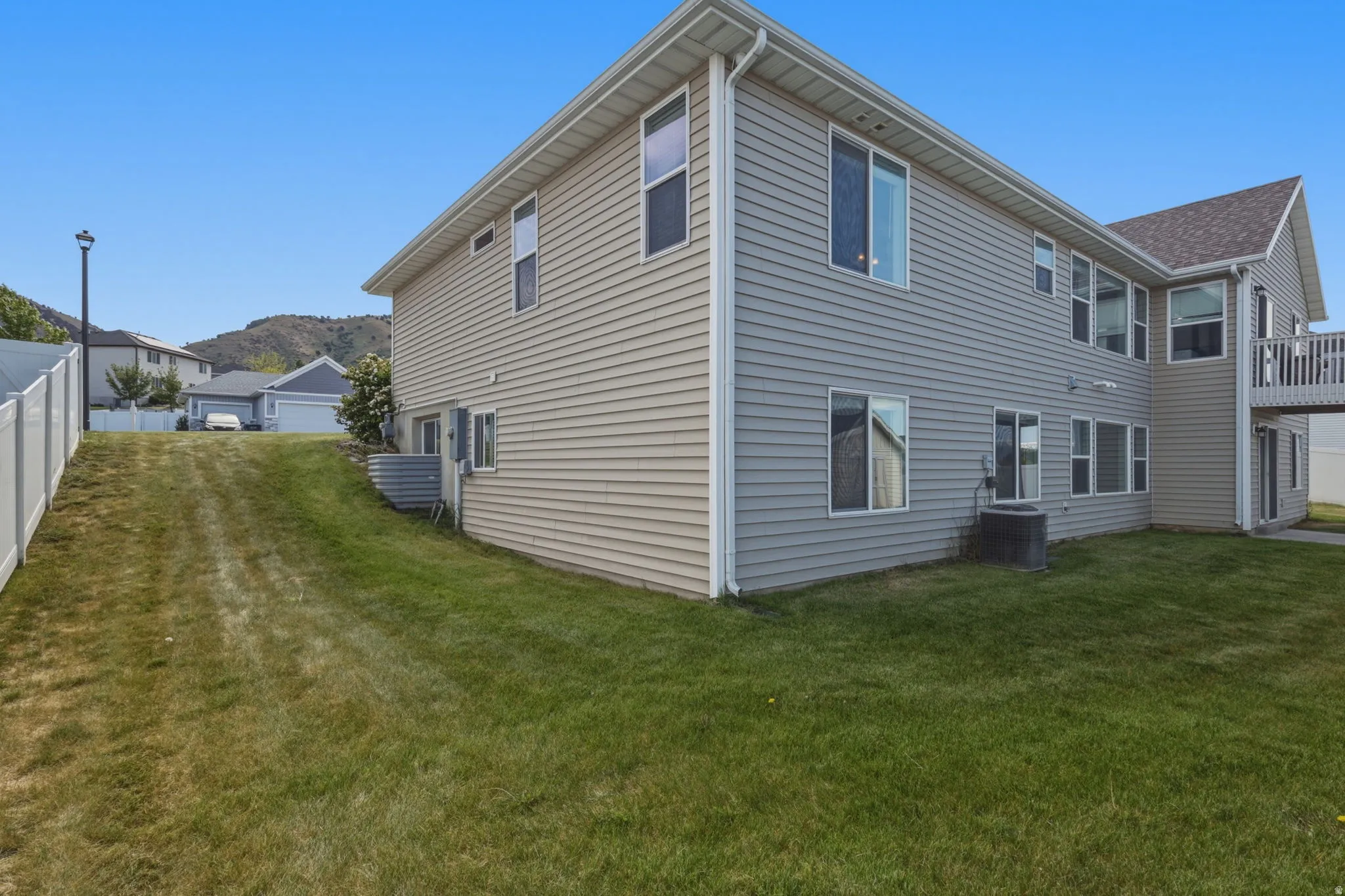 Two-story residence featuring light-colored siding and multiple windows