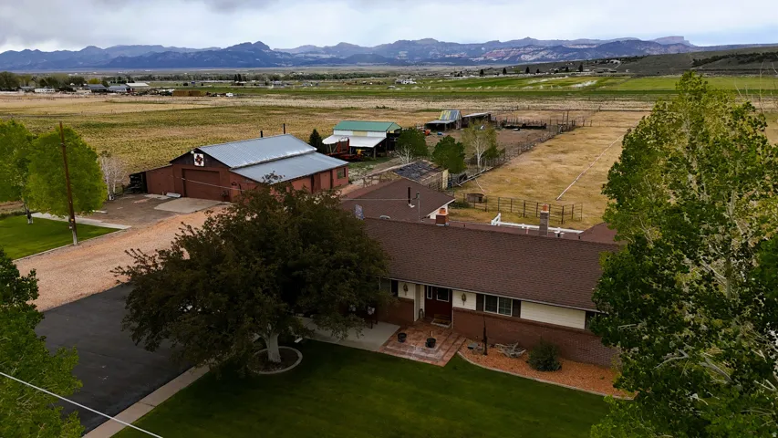 Expansive property featuring a single-story residence, a large barn with a metal roof, and additional outbuildings