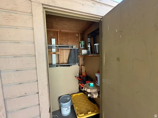Built-in storage area featuring wood paneling, wood-finish shelving, and a utilitarian door