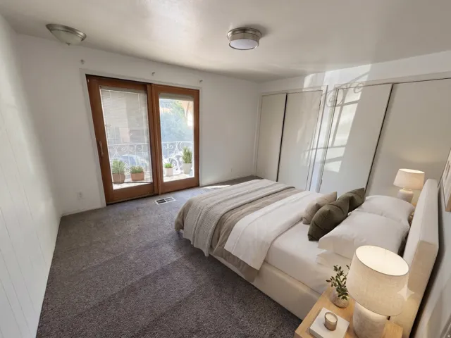 Bedroom featuring wood-finish sliding doors opening to an exterior railing