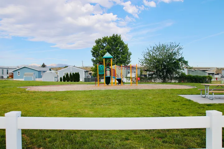 Expansive green space featuring a playground structure and picnic area