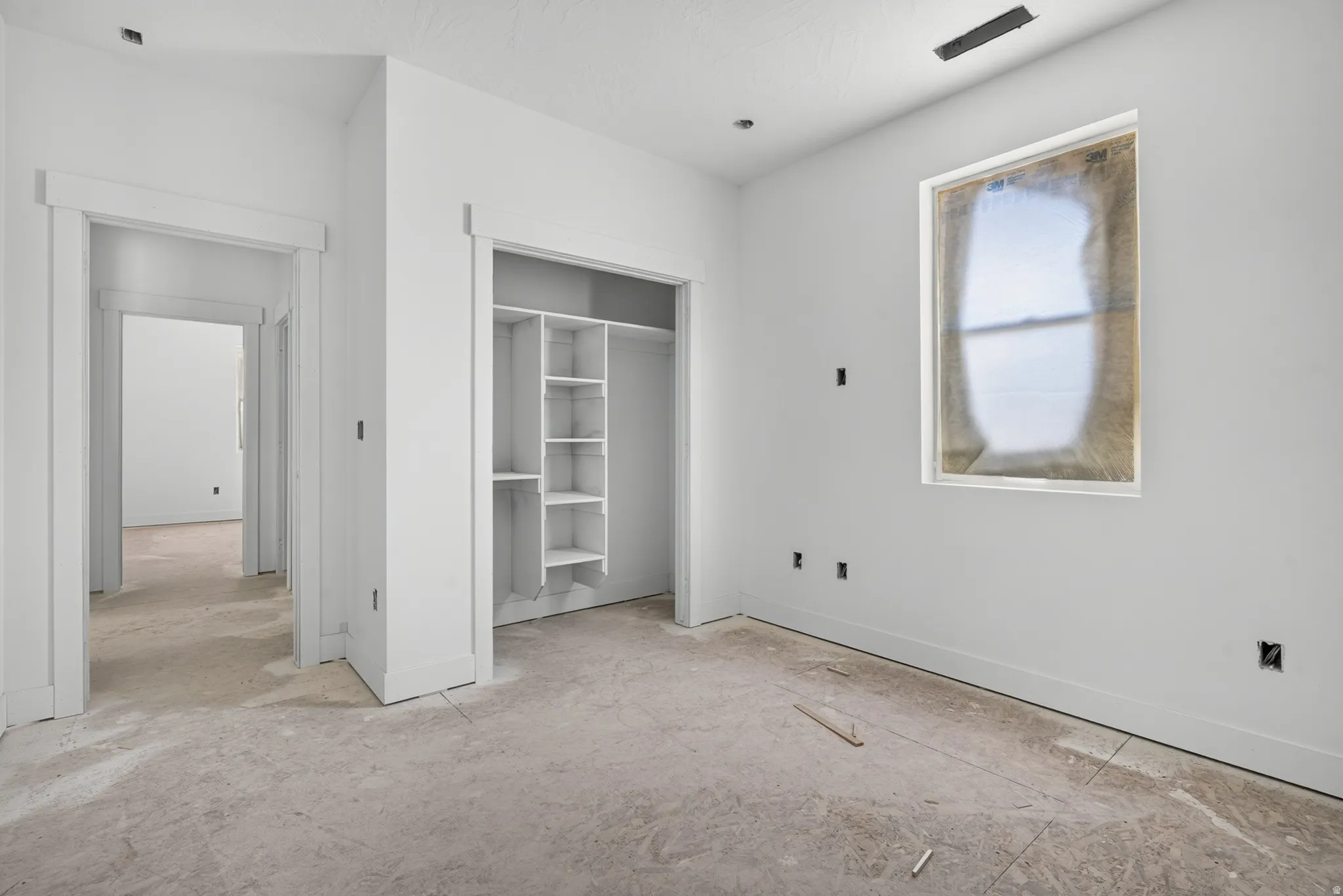 Room featuring a window, built-in closet shelving, and multiple doorways