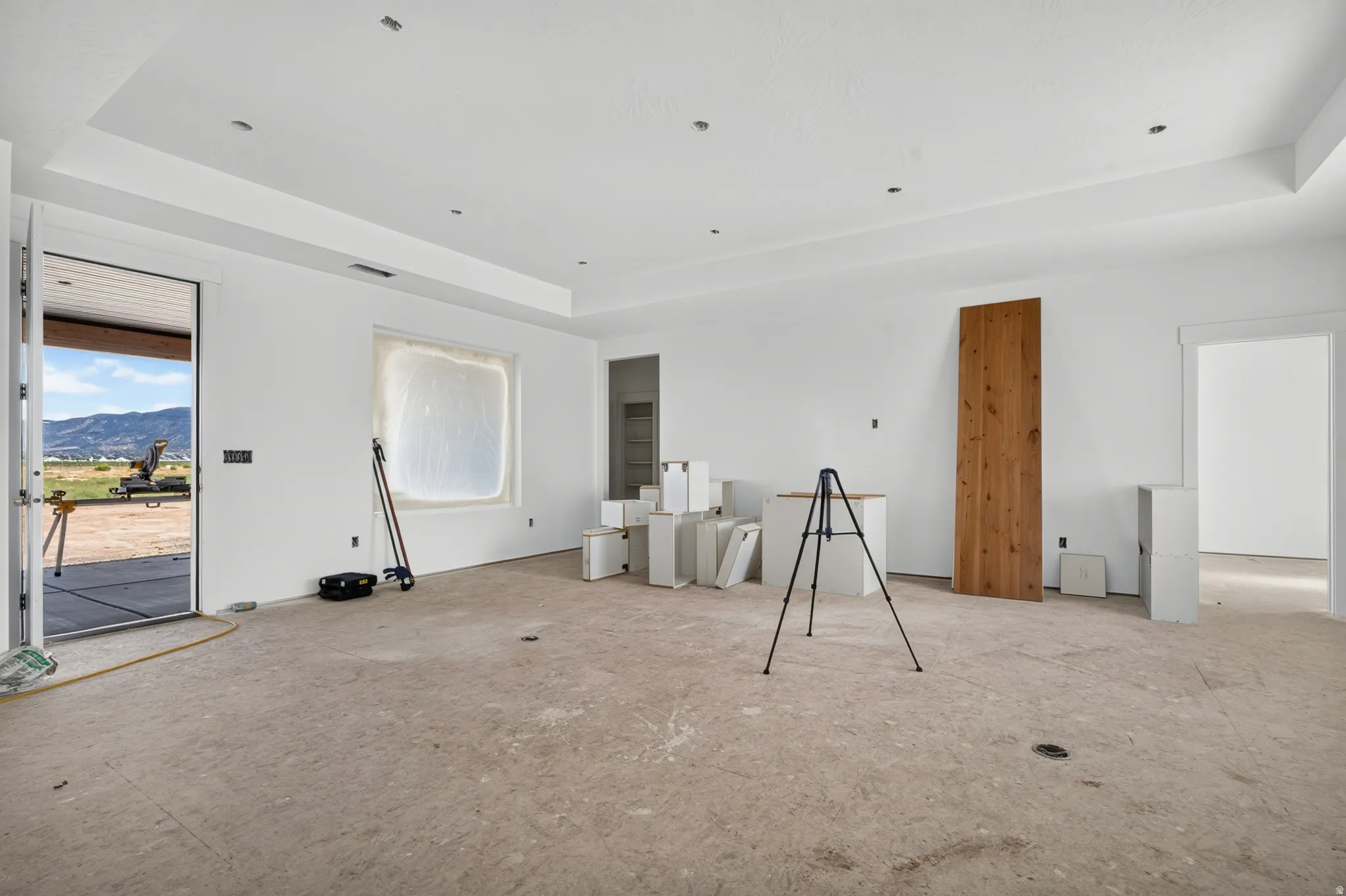 Recessed lighting, tray ceiling, outdoor patio access, mountain scenery, and an open wall space