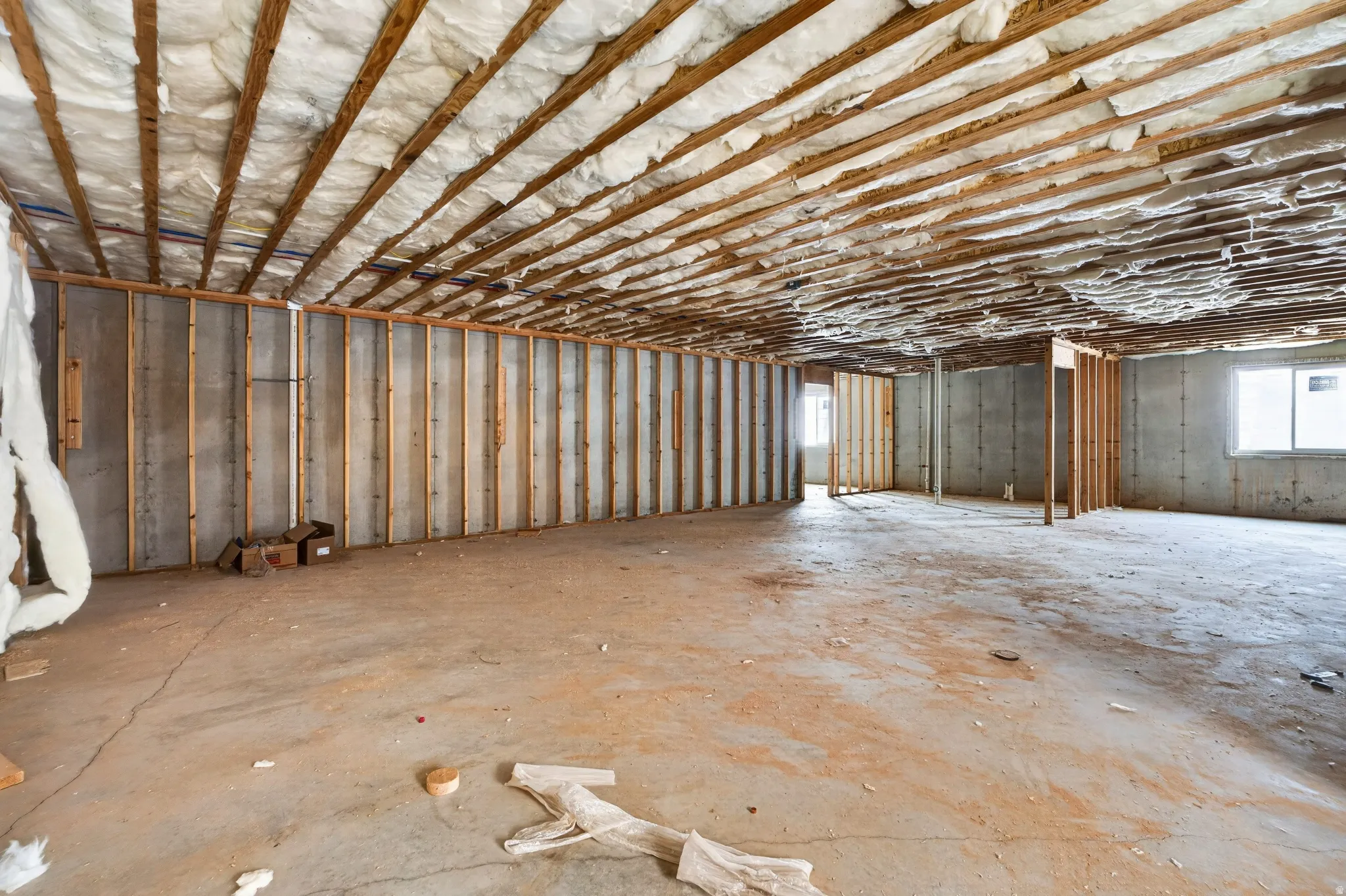 Unfinished basement with concrete flooring and exposed ceiling joists