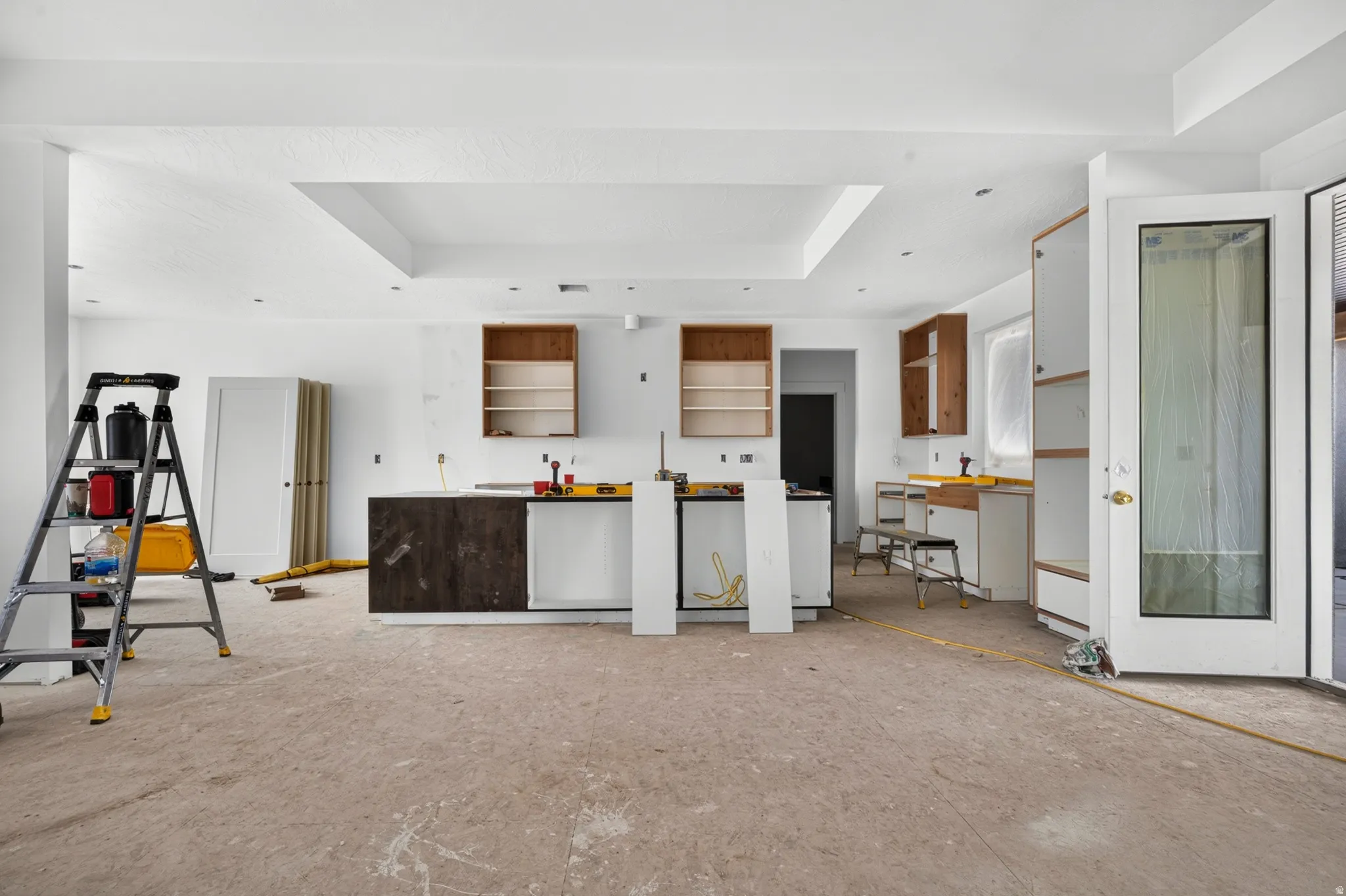 Kitchen featuring recessed lighting, tray ceiling elements, and partially installed cabinetry