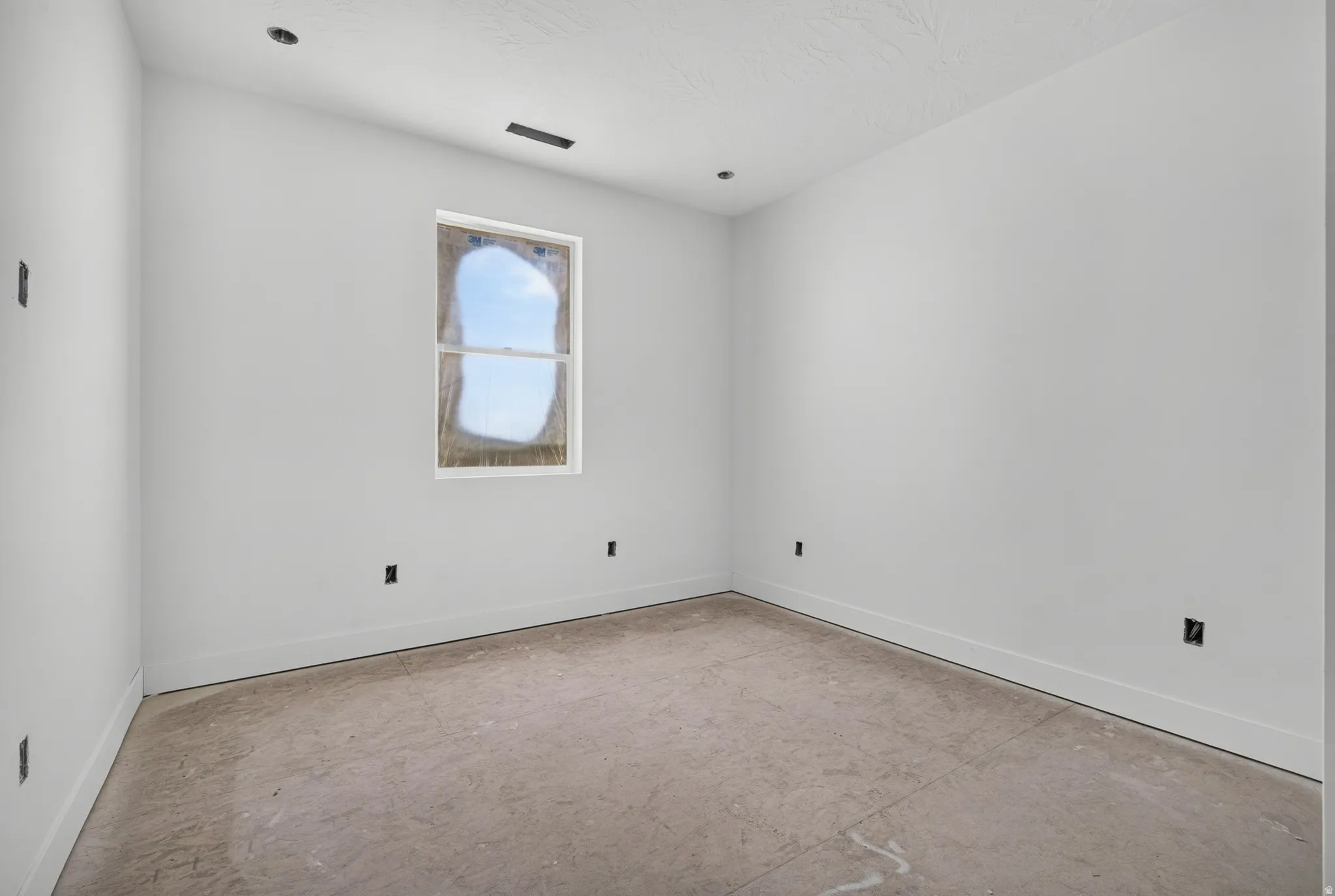 Recessed ceiling lighting with a single window and white trim, featuring unfinished flooring and white walls