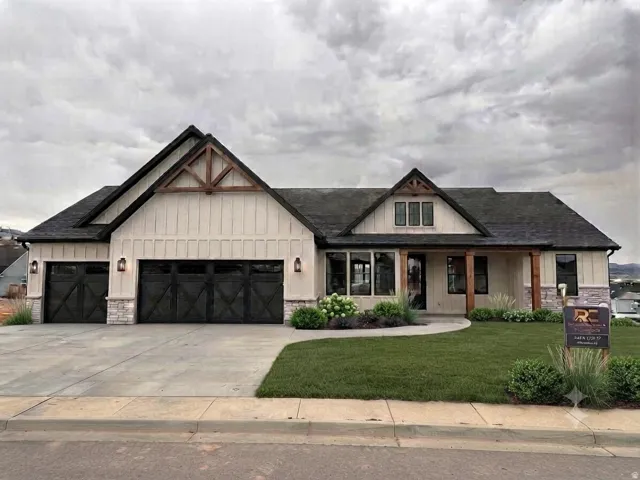 Craftsman-style exterior with wood-beam accents, board-and-batten siding, stone veneer, dark garage doors, and a covered entry