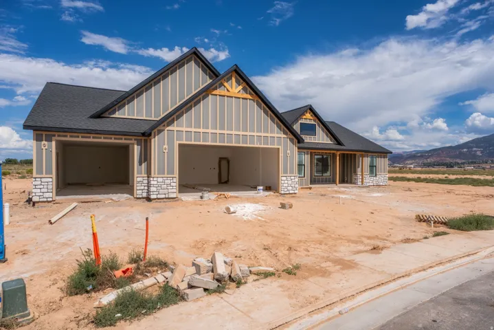 Exterior with board and batten siding, stone accents, and a dark shingled roof