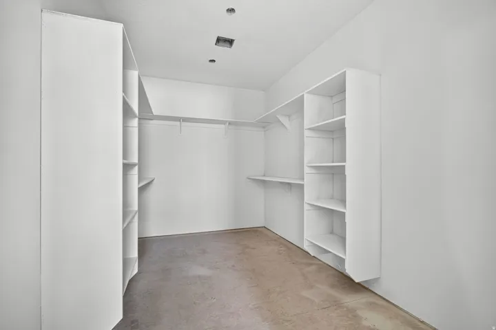 Built-in shelving, white walls, and a hanging rod