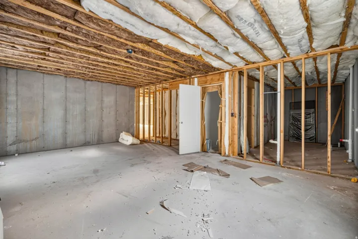 Unfinished basement with concrete flooring and exposed ceiling joists