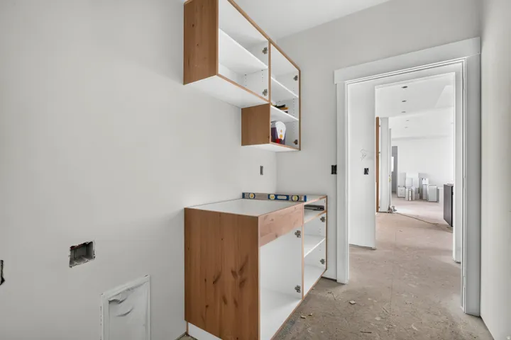 New construction featuring white walls, wood-finish cabinetry, and an open doorway