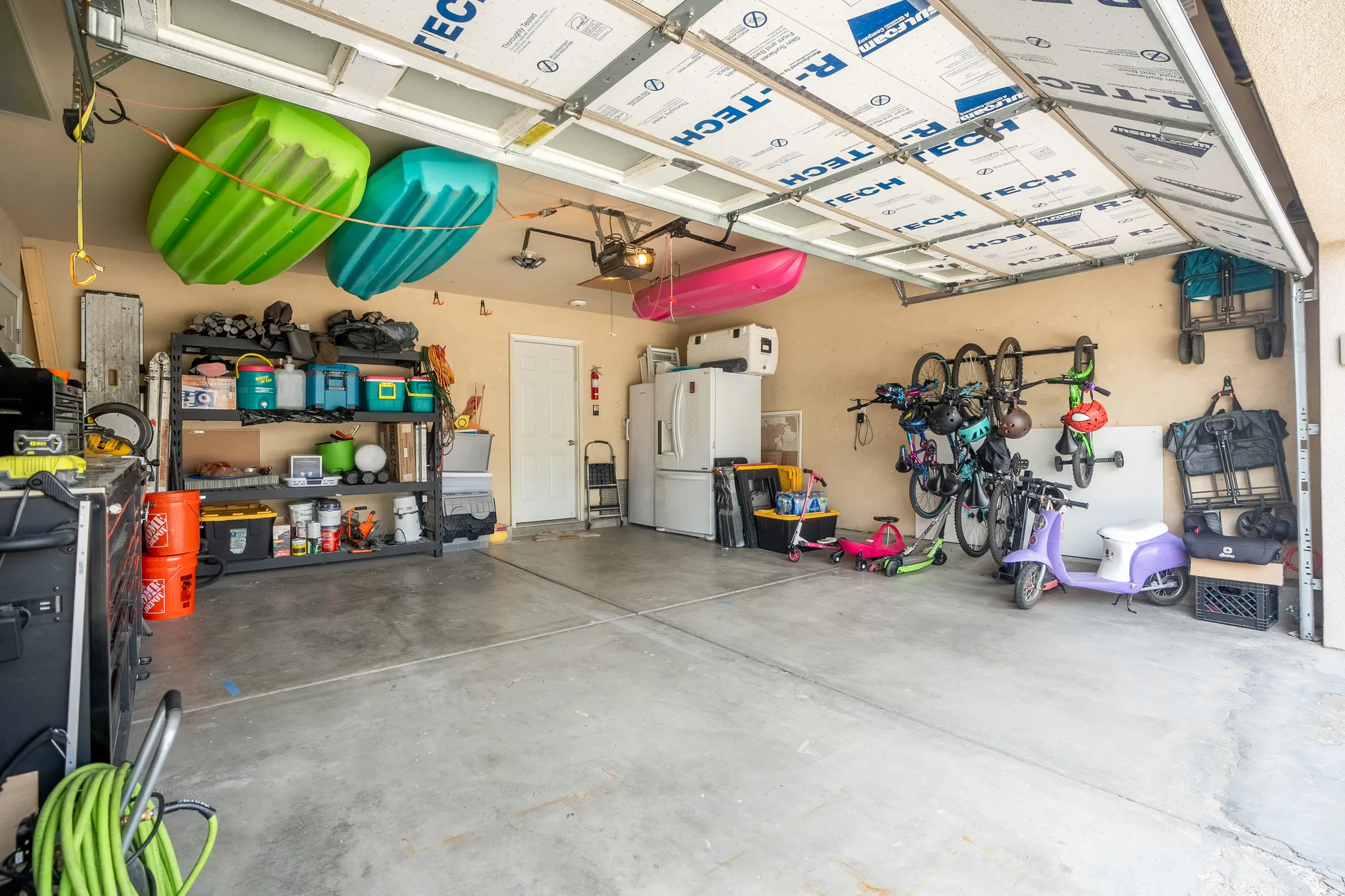 Spacious garage featuring a concrete floor, insulated overhead door, and direct access door