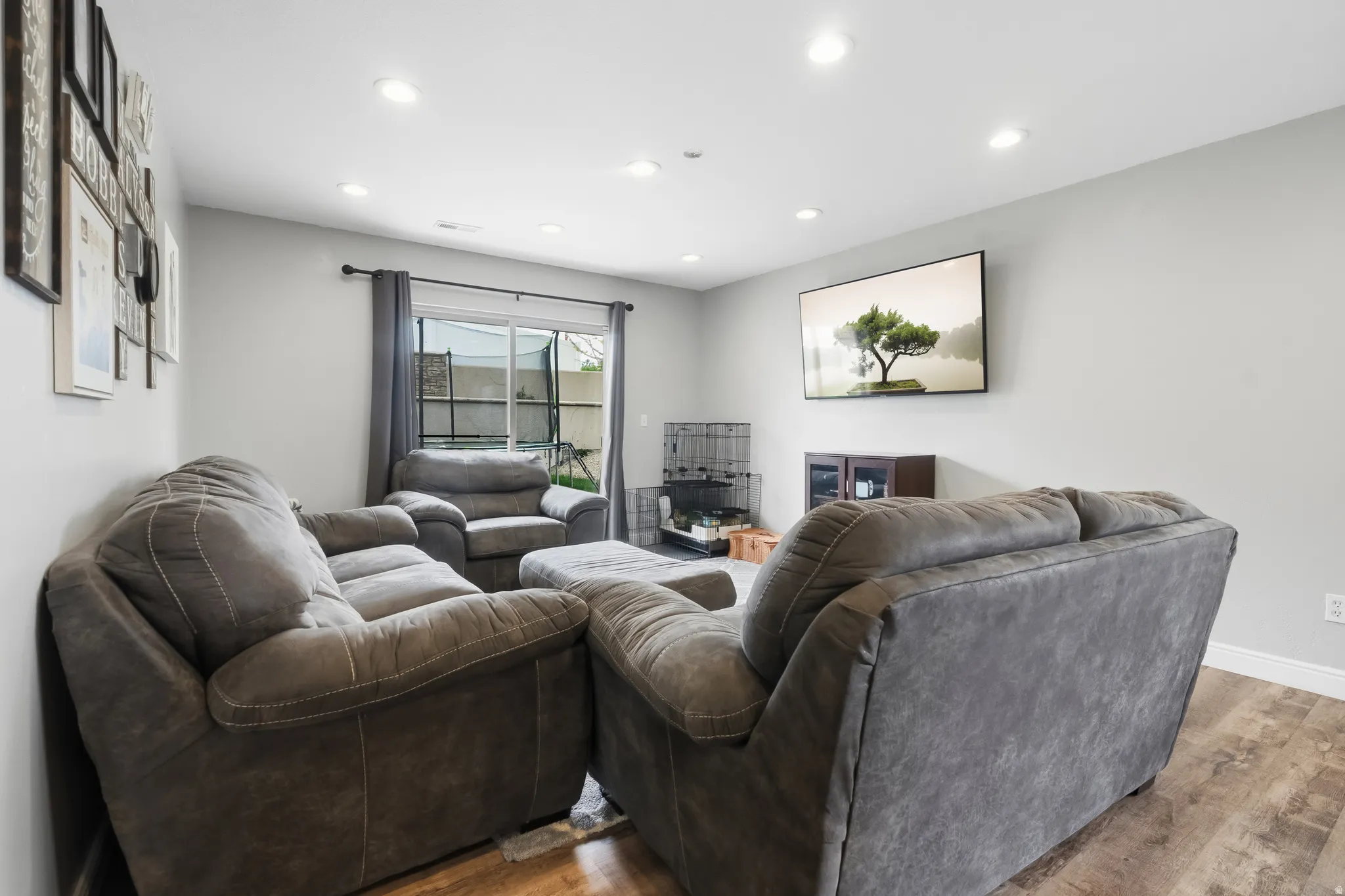 Living area featuring wood-finish flooring, recessed lighting, and a sliding glass door