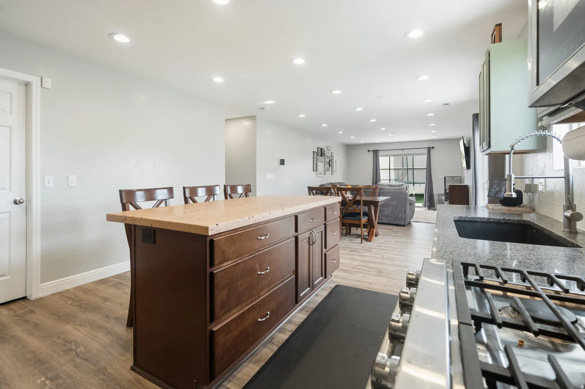 Kitchen island with a light-toned countertop and dark wood-finish cabinetry