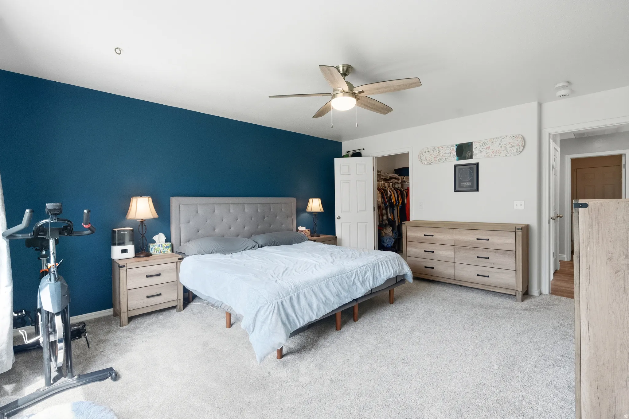 Spacious room featuring carpeting, a ceiling fan, and a built-in closet with a solid door