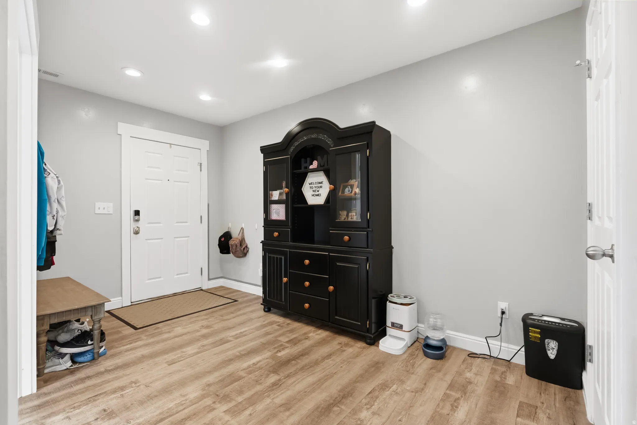 Entryway featuring wood-finish flooring, recessed lighting, and a white paneled door with smart lock hardware