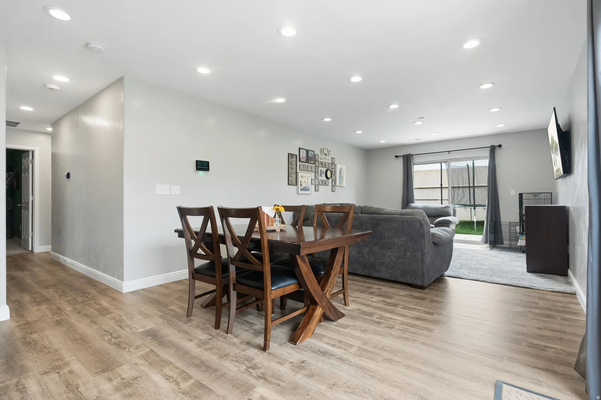 Open-concept living space featuring wood-finish flooring, recessed lighting, and light gray wall tones
