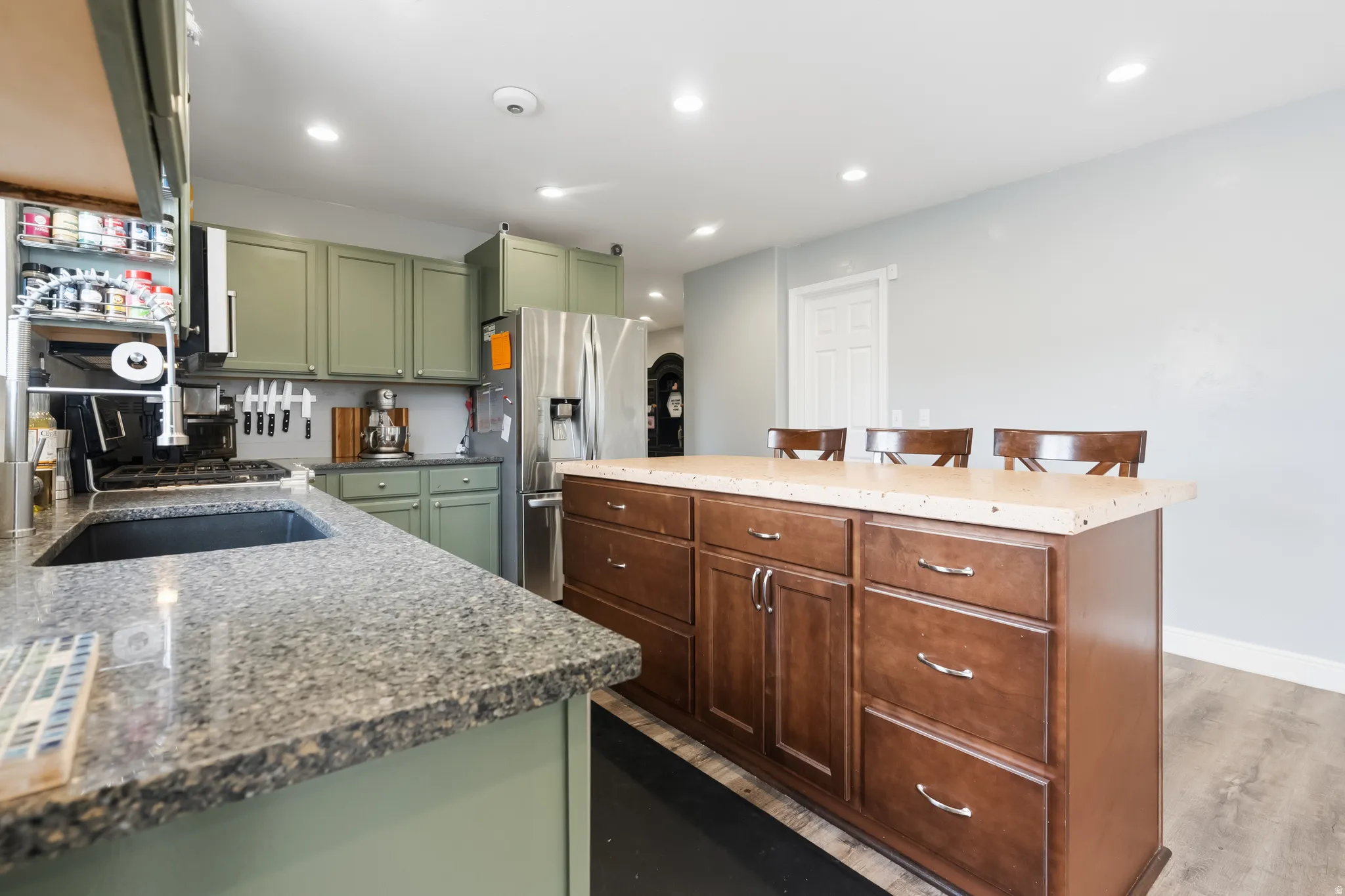 Kitchen featuring a central island with integrated storage, light-toned countertop, and recessed lighting