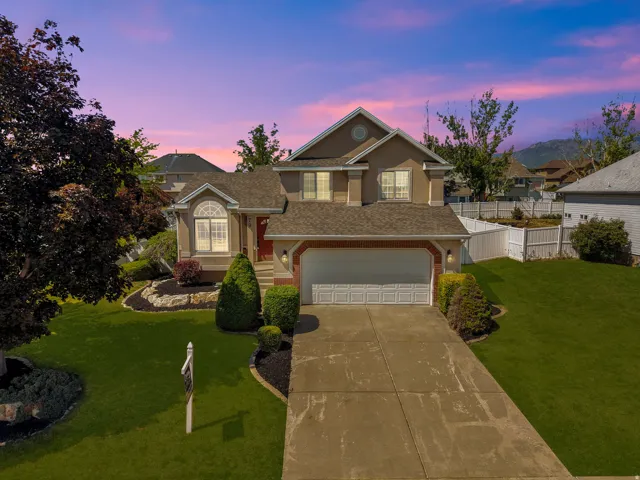 Two-story stucco residence with a prominent attached garage and a red entry door