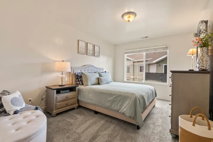 Carpeted room featuring a large window, neutral wall paint, and a built-in ceiling light fixture