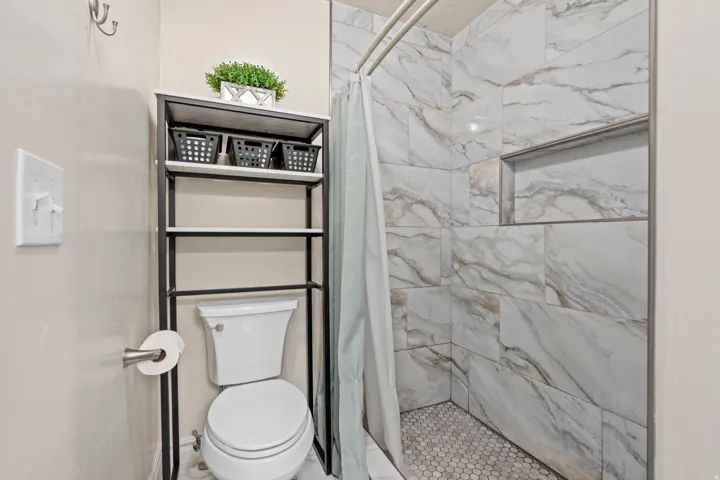 Shower with marble-look wall tiling and a built-in niche