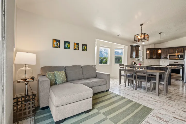 Open-concept living space featuring wood-finish flooring, recessed lighting, and large windows
