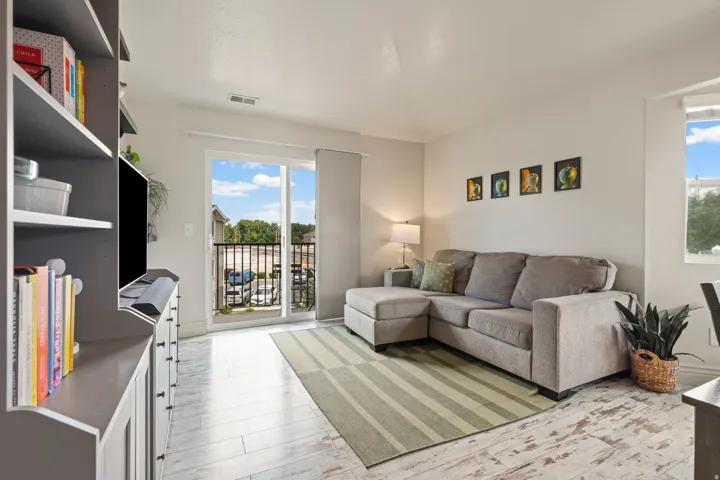 Living area featuring light wood-finish flooring and a sliding glass door to a balcony