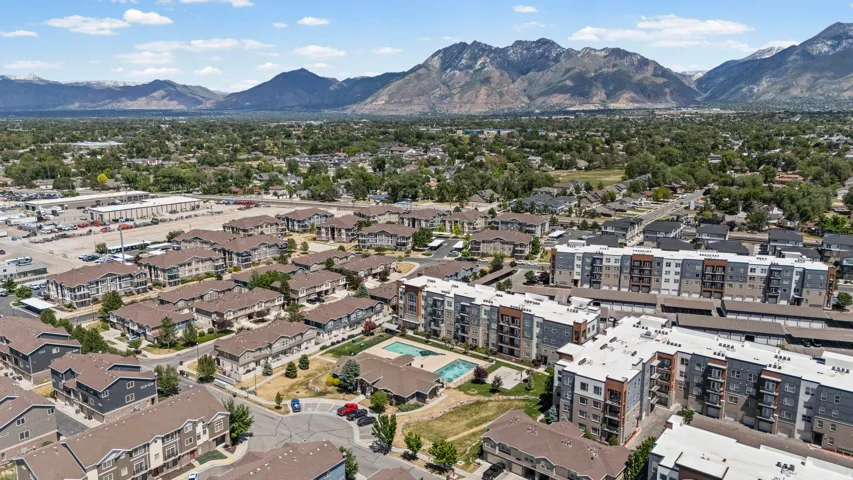 Expansive aerial view showcasing a residential community with multi-story apartment buildings and townhomes