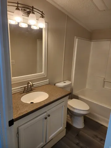 Bathroom featuring a white vanity with a speckled countertop, an undermount sink, and a brushed nickel faucet