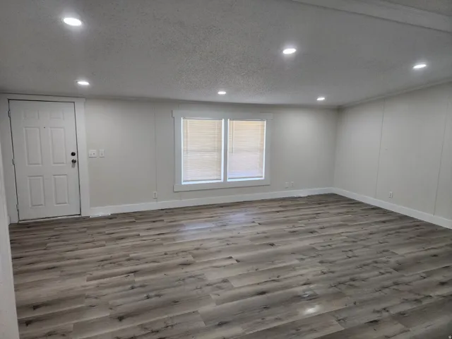 Spacious interior featuring wood-finish flooring, recessed lighting, and a neutral color palette