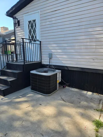 White siding exterior featuring a decorative glass paneled door and black exterior steps with railings