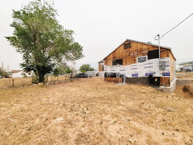 Property exterior featuring visible sheathing, an electrical meter box, and a utility pole