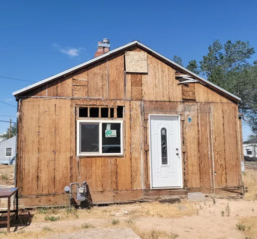 Wood-paneled exterior featuring a newly installed white entry door with an arched glass insert