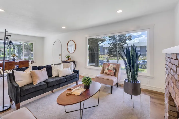 Bright living space featuring wood-finish flooring, recessed lighting, and a large picture window with white trim