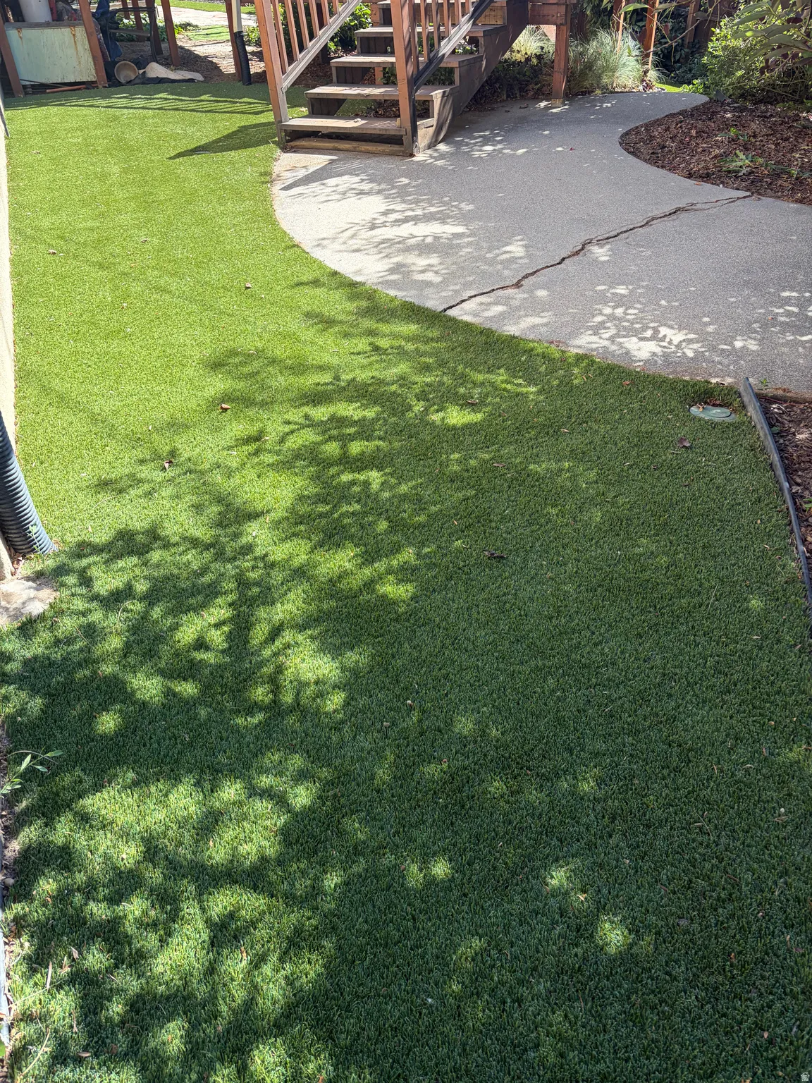 Expansive artificial turf lawn bordered by a textured concrete pathway